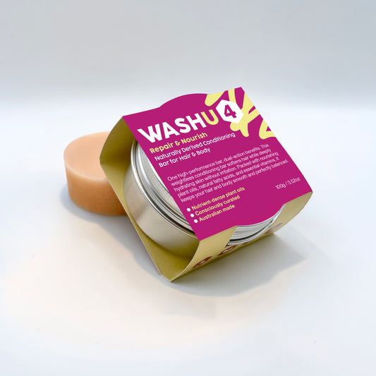 A jar of Wash4 Repair & Nourish Bar for Hair & Body shown open with a peach-colored bar of soap inside, set against a clean white background.